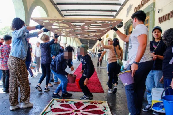 Las tradiciones de Semana Santa toman forma en San Pedro Cholula con la participación de autoridades y ciudadanía con la puesta de alfombra monumental con aserrín.