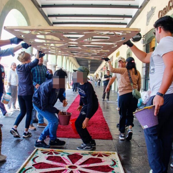 Las tradiciones de Semana Santa toman forma en San Pedro Cholula con la participación de autoridades y ciudadanía con la puesta de alfombra monumental con aserrín.